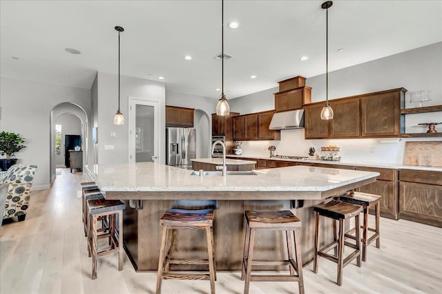 2315 W Malone St, Hanford, CA 93230 - kitchen with arched walkways, stainless steel fridge with ice dispenser, under cabinet range hood, a sink, and recessed lighting