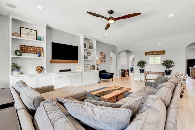 2315 W Malone St, Hanford, CA 93230 - living area featuring arched walkways, ceiling fan, light wood finished floors, built in shelves, and recessed lighting
