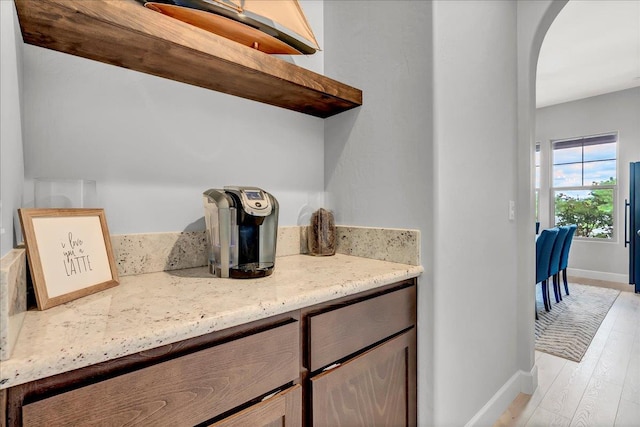 2315 W Malone St, Hanford, CA 93230 - laundry room with baseboards, arched walkways, and light wood-style floors