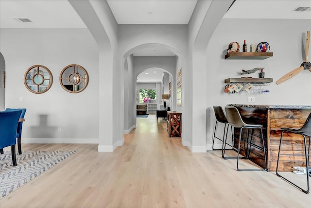 2315 W Malone St, Hanford, CA 93230 - foyer entrance with arched walkways, light wood finished floors, a bar, and baseboards