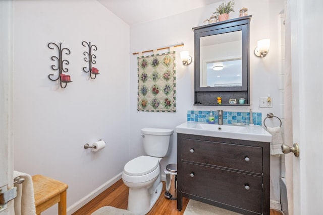 5664 Clouds Rst, Mariposa, CA 95338 - bathroom featuring wood finished floors, toilet, decorative backsplash, vanity, and baseboards