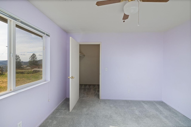 5664 Clouds Rst, Mariposa, CA 95338 - unfurnished bedroom with light carpet, a spacious closet, a ceiling fan, a closet, and baseboards