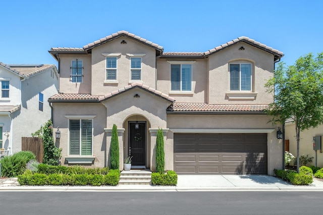 1362 E Via Viola Way, Fresno, CA 93730 - mediterranean / spanish house featuring a tile roof, a garage, stucco siding, and driveway