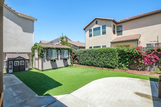 1362 E Via Viola Way, Fresno, CA 93730 - view of green lawn featuring a storage unit, a patio area, and an outbuilding