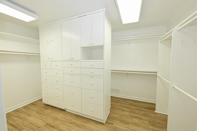 walk in closet with wood finished floors