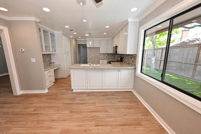 5088 N Forkner Ave, Fresno, CA 93711 - kitchen with appliances with stainless steel finishes, a peninsula, white cabinetry, backsplash, and ornamental molding