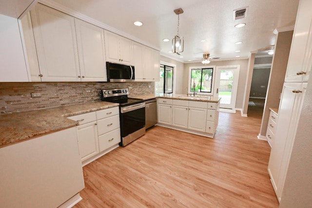 kitchen with appliances with stainless steel finishes, a peninsula, white cabinets, crown molding, and recessed lighting