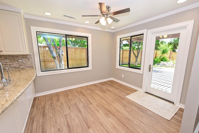 unfurnished dining area featuring light wood finished floors, baseboards, a ceiling fan, ornamental molding, and recessed lighting