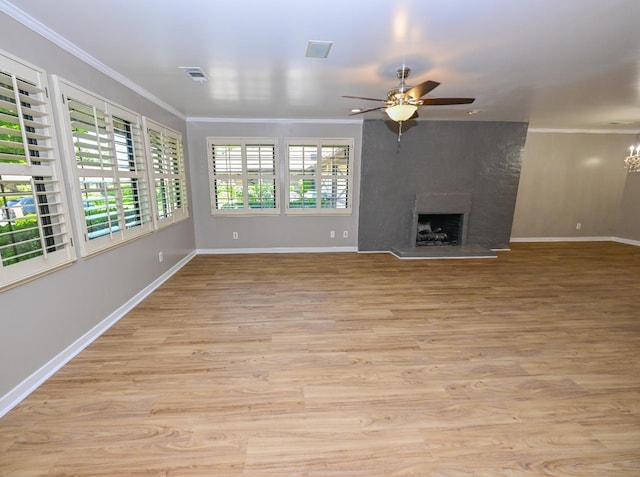 unfurnished living room with crown molding, ceiling fan, baseboards, light wood-type flooring, and a fireplace