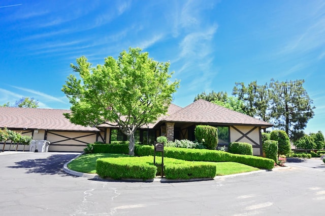 view of front of house featuring a garage, asphalt driveway, and stucco siding