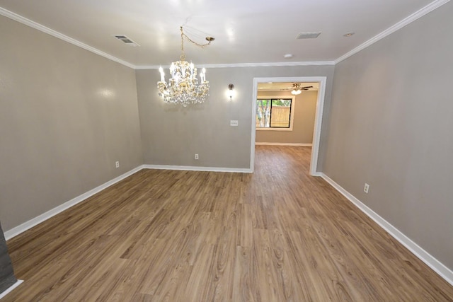 empty room featuring ornamental molding, wood finished floors, baseboards, a chandelier, and ceiling fan