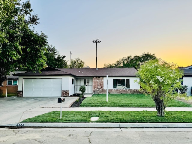 2332 S Jackson Ave, Fresno, CA 93725 - ranch-style home with an attached garage, concrete driveway, a front lawn, and stone siding