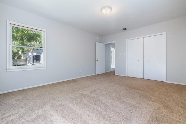 unfurnished bedroom featuring carpet floors, baseboards, and a closet