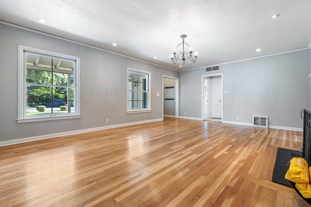 unfurnished living room featuring a chandelier, light wood-style floors, baseboards, crown molding, and recessed lighting