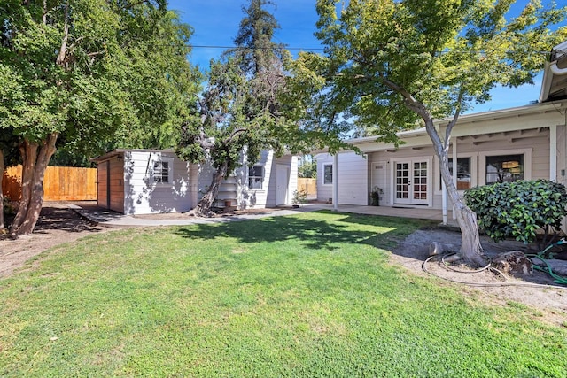 view of yard featuring french doors, an outdoor structure, and a storage shed
