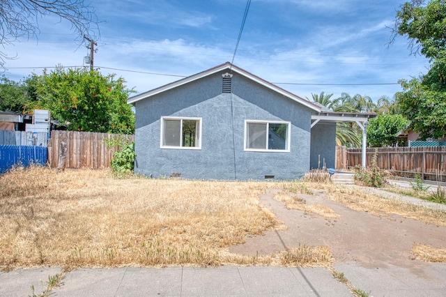 4487 E Bend Ave, Fresno, CA 93702 - view of property exterior with stucco siding, fence, and crawl space