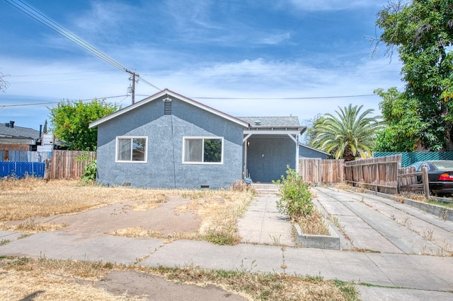 4487 E Bend Ave, Fresno, CA 93702 - view of front of home with fence, stucco siding, and crawl space