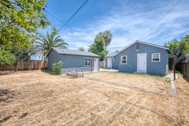 4487 E Bend Ave, Fresno, CA 93702 - back of house with a fenced backyard, stucco siding, and an outdoor structure