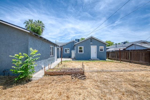 4487 E Bend Ave, Fresno, CA 93702 - rear view of house with a garden and stucco siding