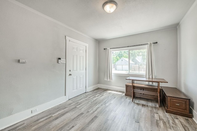 4487 E Bend Ave, Fresno, CA 93702 - entryway with light wood-type flooring, crown molding, baseboards, and a textured ceiling