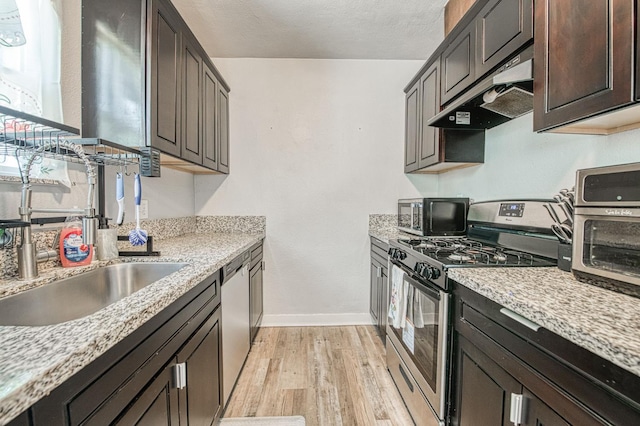 4487 E Bend Ave, Fresno, CA 93702 - kitchen featuring appliances with stainless steel finishes, under cabinet range hood, light wood-style floors, baseboards, and dark brown cabinetry