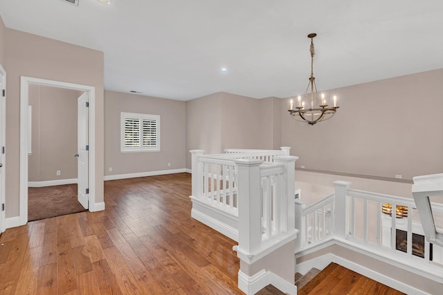 10717 N Bunkerhill Dr, Fresno, CA 93730 - corridor featuring a chandelier, light wood-type flooring, an upstairs landing, recessed lighting, and baseboards