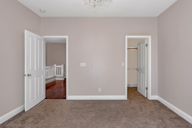 10717 N Bunkerhill Dr, Fresno, CA 93730 - unfurnished bedroom with carpet, a chandelier, a spacious closet, and baseboards