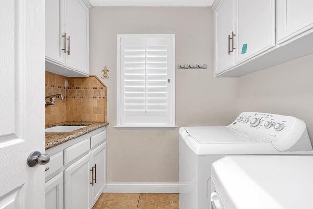 10717 N Bunkerhill Dr, Fresno, CA 93730 - washroom featuring washing machine and clothes dryer, baseboards, cabinet space, and light tile patterned flooring