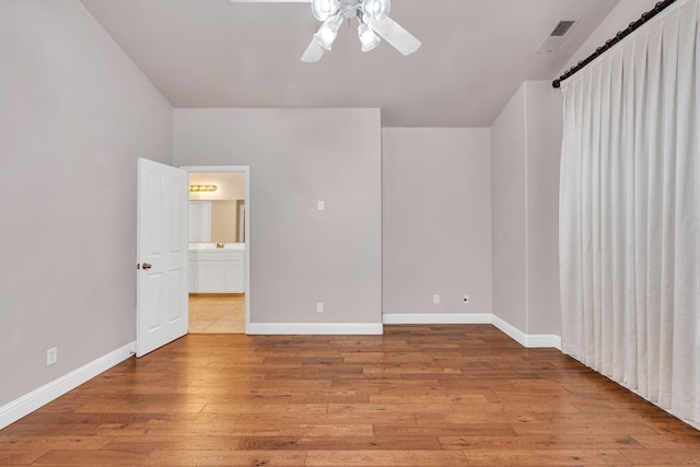 10717 N Bunkerhill Dr, Fresno, CA 93730 - spare room with hardwood / wood-style floors, a ceiling fan, and baseboards