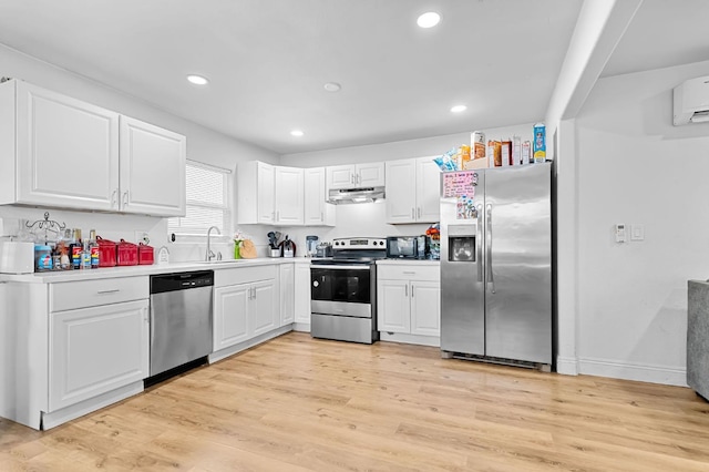 2157 Locust St, Selma, CA 93662 - kitchen with stainless steel appliances, under cabinet range hood, white cabinetry, a sink, and light wood-type flooring