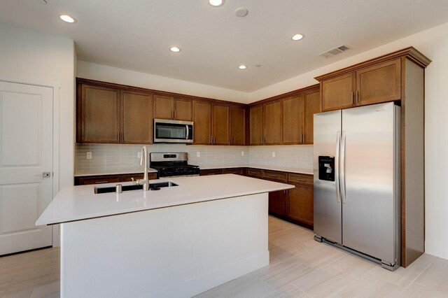 495 Thunder Rd S, Madera, CA 93636 - kitchen with appliances with stainless steel finishes, a sink, a center island with sink, decorative backsplash, and recessed lighting