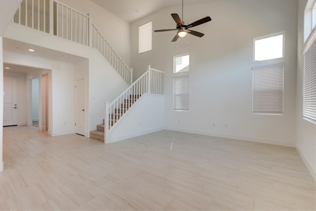 495 Thunder Rd S, Madera, CA 93636 - unfurnished living room featuring stairway, a towering ceiling, a ceiling fan, wood finished floors, and baseboards