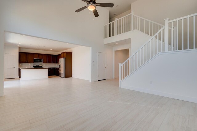 495 Thunder Rd S, Madera, CA 93636 - unfurnished living room featuring a high ceiling, ceiling fan, stairs, recessed lighting, and baseboards