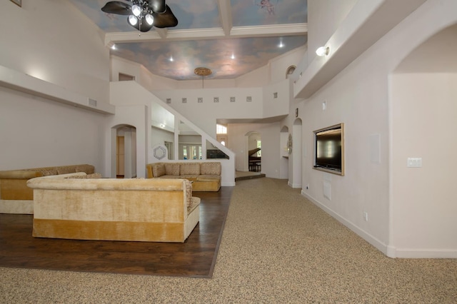 8067 E Belmont Ave, Fresno, CA 93737 - living room with arched walkways, ceiling fan, stairway, a towering ceiling, and baseboards