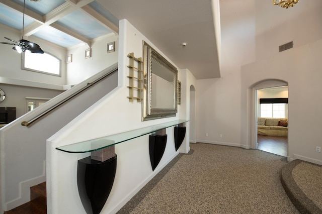 8067 E Belmont Ave, Fresno, CA 93737 - hallway with arched walkways, a high ceiling, stairs, beamed ceiling, and coffered ceiling