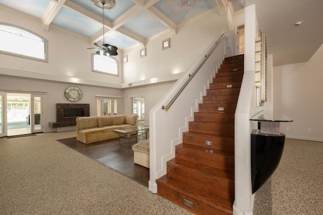 8067 E Belmont Ave, Fresno, CA 93737 - stairway with ceiling fan, coffered ceiling, carpet floors, beam ceiling, and a towering ceiling
