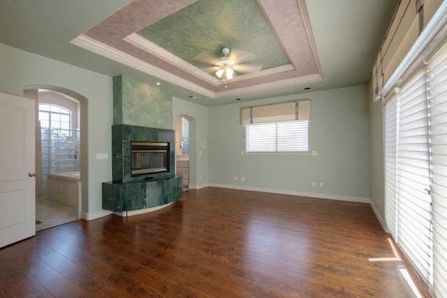 8067 E Belmont Ave, Fresno, CA 93737 - unfurnished living room featuring a tray ceiling, arched walkways, ceiling fan, hardwood / wood-style flooring, and ornamental molding