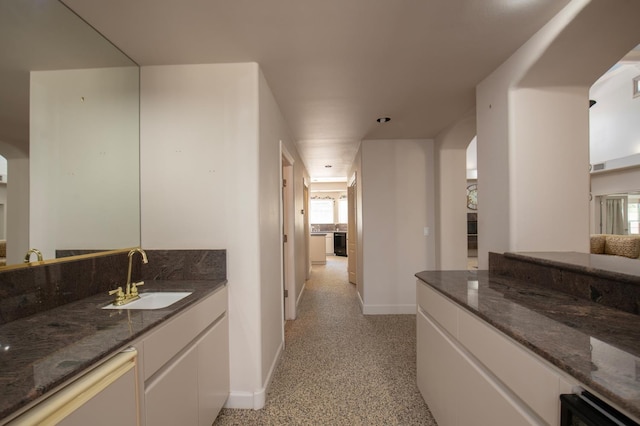 8067 E Belmont Ave, Fresno, CA 93737 - bathroom with baseboards, vanity, and speckled floor