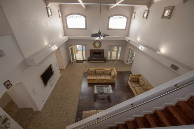 8067 E Belmont Ave, Fresno, CA 93737 - living room featuring a glass covered fireplace, a towering ceiling, ceiling fan, baseboards, and beamed ceiling