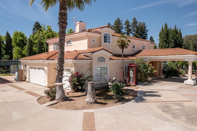 8067 E Belmont Ave, Fresno, CA 93737 - mediterranean / spanish-style home featuring concrete driveway, a chimney, a tile roof, and stucco siding