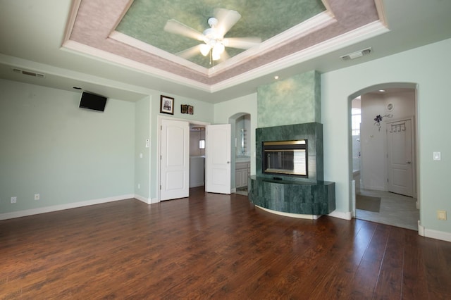 8067 E Belmont Ave, Fresno, CA 93737 - unfurnished living room featuring a raised ceiling, arched walkways, crown molding, a tile fireplace, and a ceiling fan