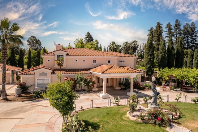 8067 E Belmont Ave, Fresno, CA 93737 - back of house with a tiled roof, a chimney, stucco siding, and a lawn