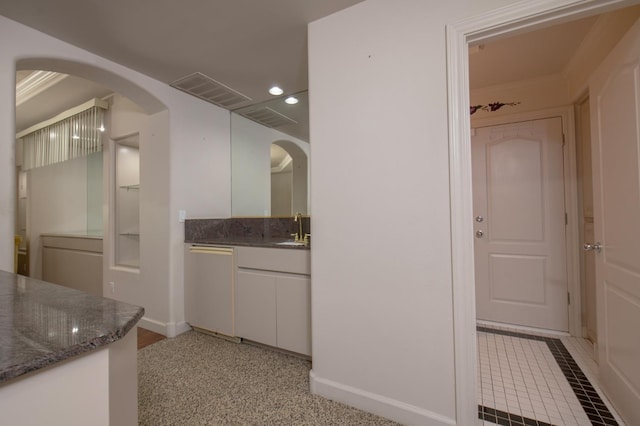 8067 E Belmont Ave, Fresno, CA 93737 - kitchen with a sink, white cabinets, recessed lighting, arched walkways, and dark stone countertops
