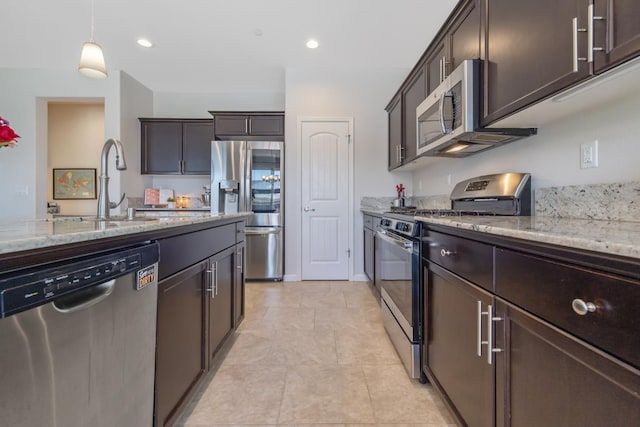 6326 W Sweet Ct, Visalia, CA 93291 - kitchen featuring stainless steel appliances, dark brown cabinetry, light stone counters, pendant lighting, and recessed lighting