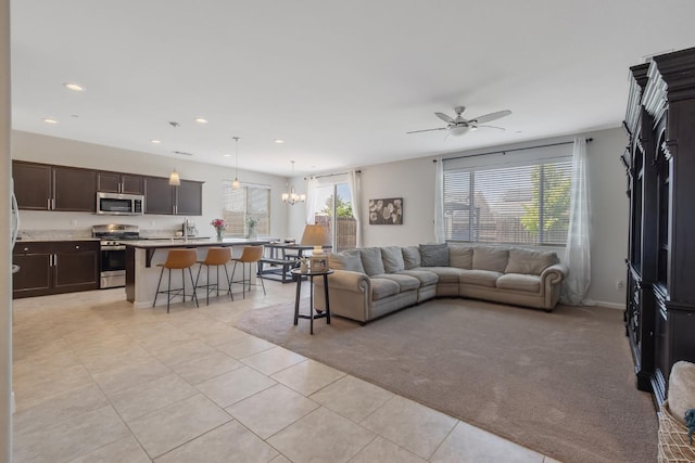 6326 W Sweet Ct, Visalia, CA 93291 - living room featuring light tile patterned flooring, recessed lighting, ceiling fan, a chandelier, and baseboards