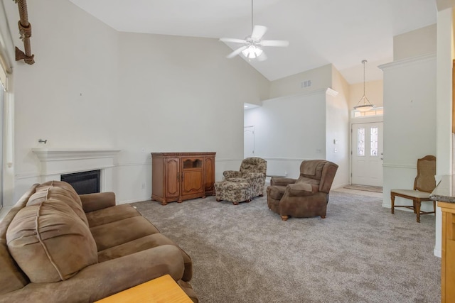 living area featuring high vaulted ceiling, light colored carpet, a ceiling fan, and a glass covered fireplace