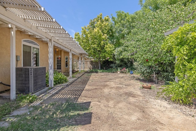 view of yard with a pergola, central air condition unit, and fence