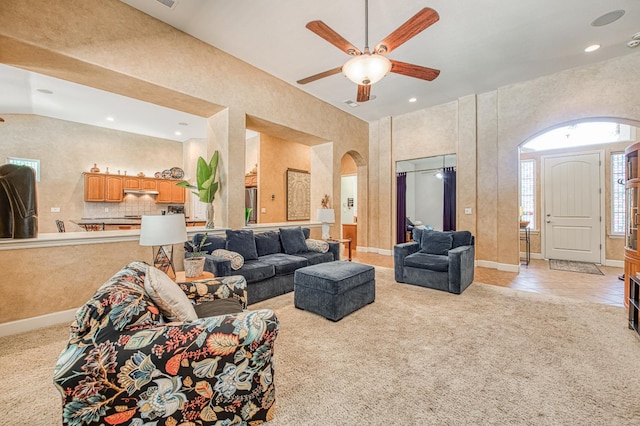 living area featuring arched walkways, light carpet, a ceiling fan, recessed lighting, and high vaulted ceiling