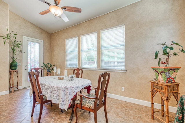 dining area with vaulted ceiling, a ceiling fan, light tile patterned flooring, and baseboards