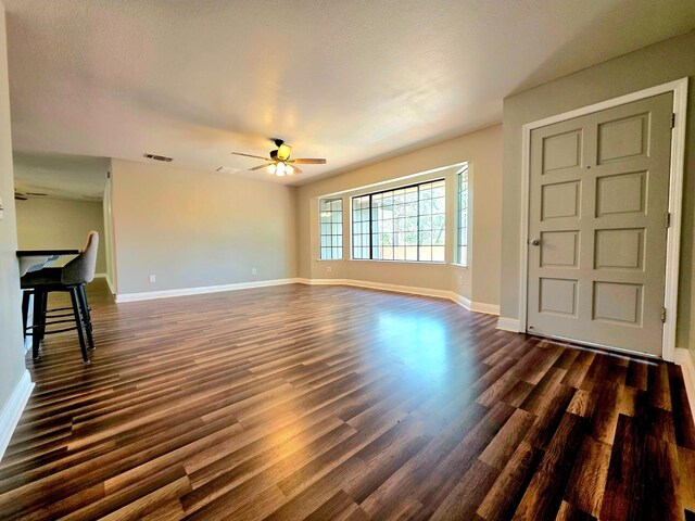 41549 Long Hollow Dr, Coarsegold, CA 93614 - unfurnished living room featuring a ceiling fan, dark wood-style floors, and baseboards